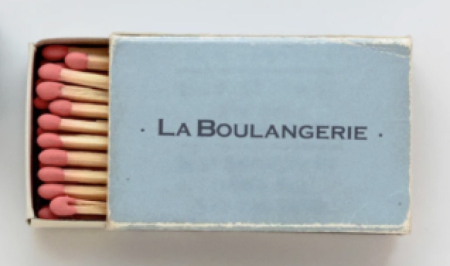 A pale blue matchbox reading La Boulangerie, open to show pink-tipped matches